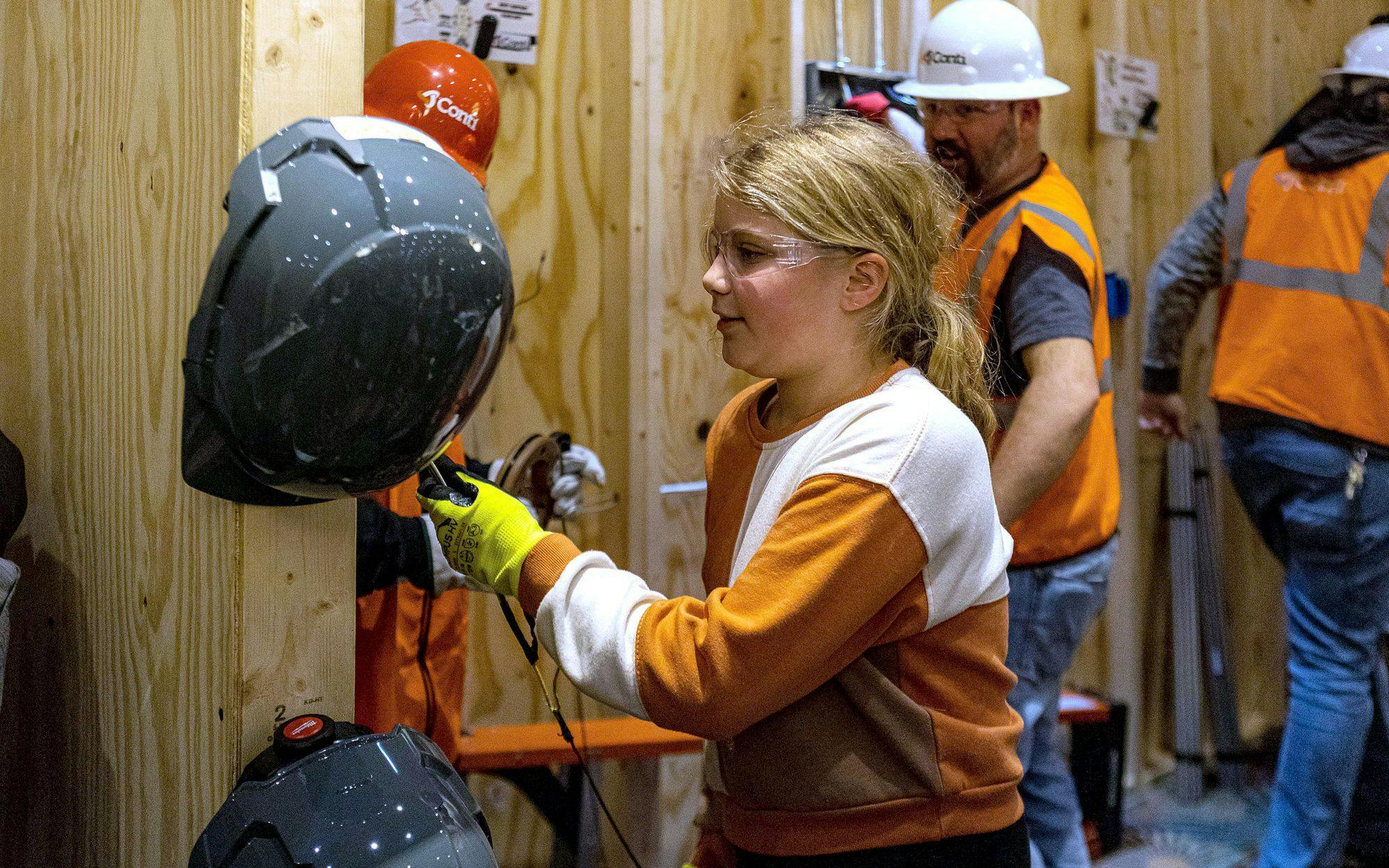 Girls participate in construction activities.