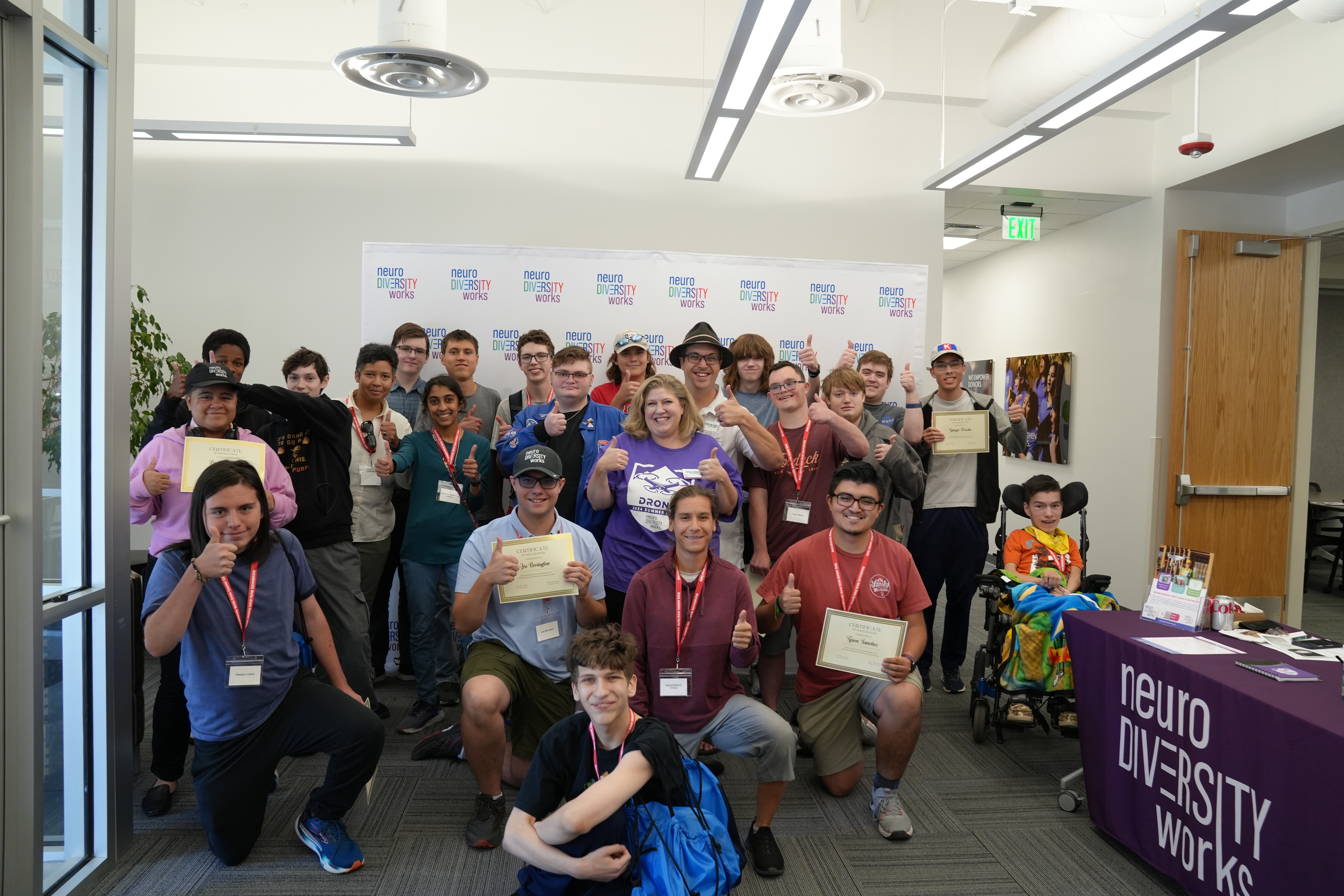 a group of women and men showing off their certificates for a drone workshop