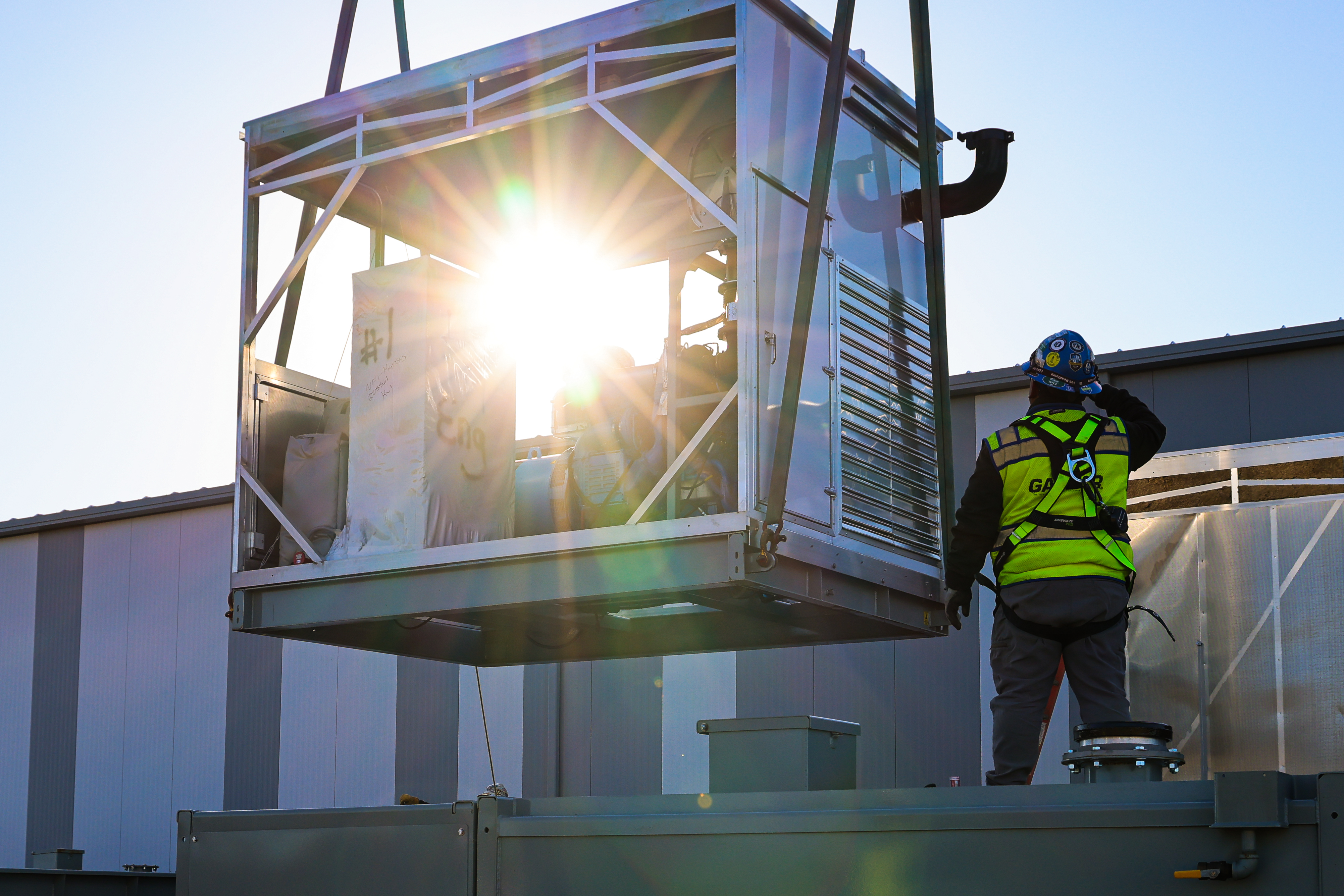 gaylor hoisting an hvac unit onto a building