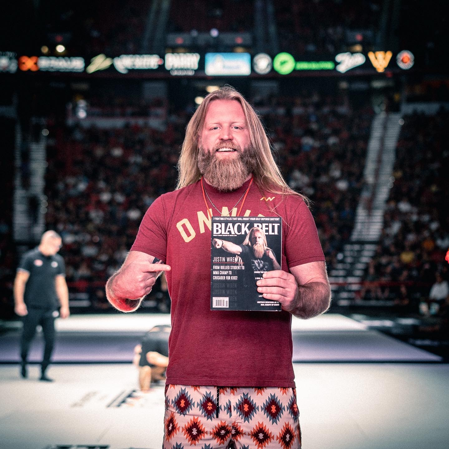 a man pointing to himself on the cover of a magazine while standing inside of a boxing ring.